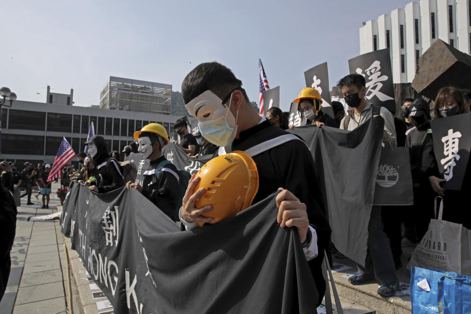 University students pay a silent tribute to the victims in the anti-government protest movement before their graduation ceremony at the Chinese University of Hong Kong, Thursday, Nov. 7, 2019, in Hong Kong. (AP Photo/Kin Cheung)