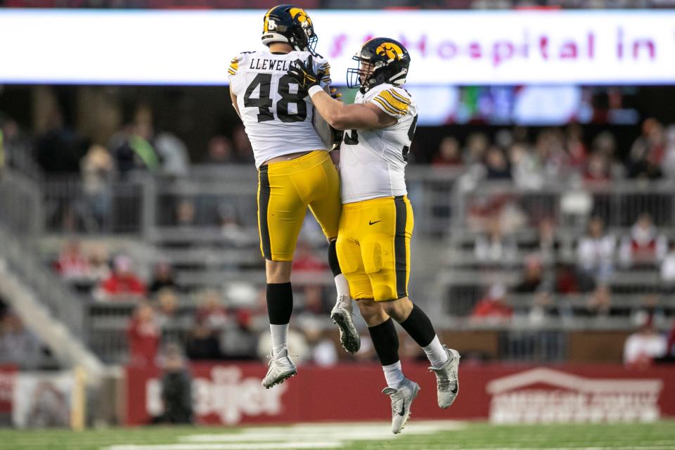 Iowa Hawkeyes defensive lineman Max Llewellyn (48) and Iowa Hawkeyes defensive lineman Aaron Graves (95) celebrate a stop on fourth down during an NCAA college football game against Wisconsin on Saturday, Oct. 14, 2023, in Madison, Wis. (Geoff Stellfox/The Gazette via AP)