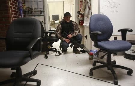 Wes Kjar, an occupier, crouches after a door was rattled in an office at the Malheur National Wildlife Refuge near Burns, Oregon, January 6, 2016. REUTERS/Jim Urquhart