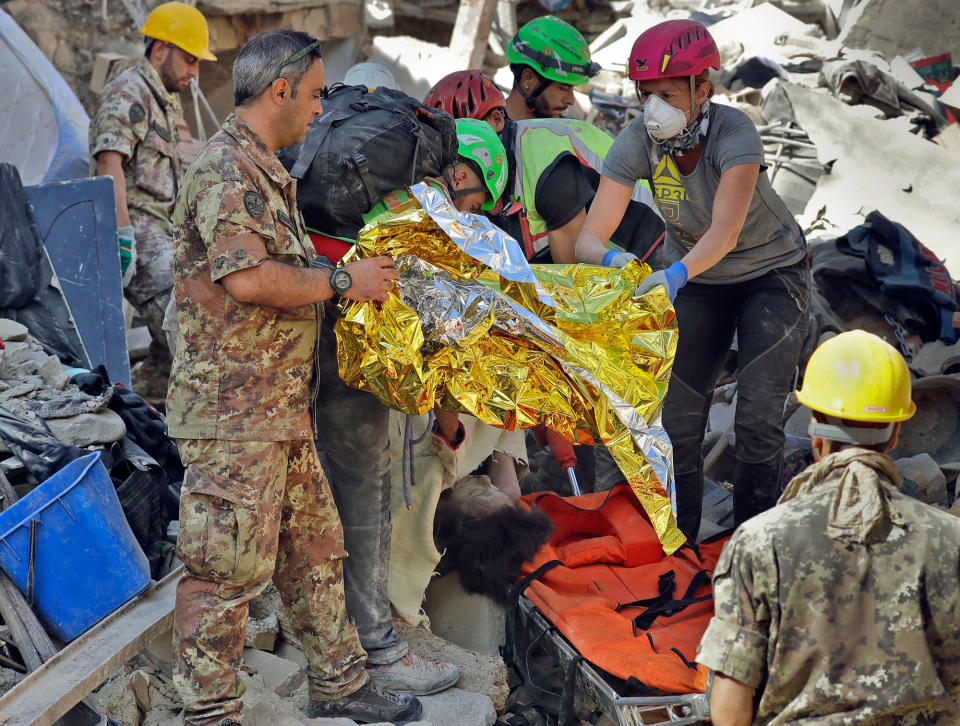 <p>The body of a victim is pulled out of the rubble following an earthquake in Amatrice Italy, Wednesday, Aug. 24, 2016. (AP Photo/Alessandra Tarantino) </p>