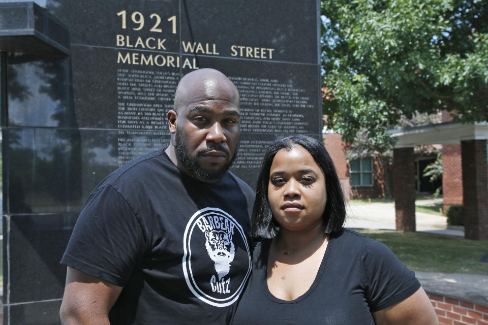 Shawn-Du Stackhouse, left, and Chelsea Guillory, right, pose for a photo at the Black Wall Street Memorial in Tulsa, Okla., Monday, June 15, 2020. For Stackhouse, a barber from the Washington, D.C. area and one of those visiting the Tulsa massacre memorials on this day, the proof that cell-phone videos provided of killings of African-Americans today somehow make the killings of the past, like Tulsa's, more real as well. (AP Photo/Sue Ogrocki)