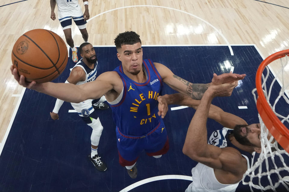 Denver Nuggets forward Michael Porter Jr. (1) shoots as Minnesota Timberwolves center Rudy Gobert, right, defends during the first half of Game 3 of an NBA basketball second-round playoff series Friday, May 10, 2024, in Minneapolis. (AP Photo/Abbie Parr)