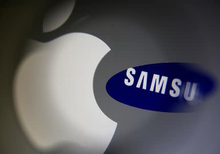 A Samsung logo and a logo of Apple are seen in this September 23, 2014 illustration photo in Sarajevo. REUTERS/Dado Ruvic/Files