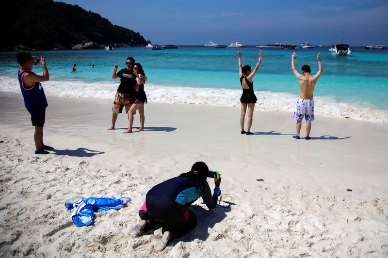 Chinese tourists pose on a beach at an island in Phang-Nga province