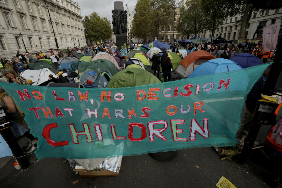 Tents put up by Extinction Rebellion climate change protesters sit blocking the road on Whitehall in London, Tuesday, Oct. 8, 2019. Hundreds of climate change activists camped out in central London on Tuesday during a second day of world protests by the Extinction Rebellion movement to demand more urgent actions to counter global warming. (AP Photo/Matt Dunham)