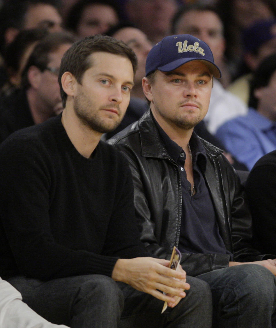 FILE - In this Dec. 22, 2009, file photo, actors Tobey Maguire, left, and Leonardo DiCaprio watch an NBA basketball game between Los Angeles Lakers and the Oklahoma City Thunder in Los Angeles. DiCaprio and Maguire lead a cast of stars in a new public service announcement urging young voters to use social media to express the issues most important to them in the upcoming election.(AP Photo/Jae C. Hong, File)