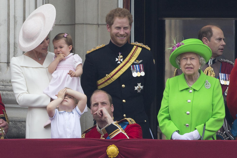 (L-R) Britain's Catherine, Duchess of Cambridge holding her daughter Princess Charlotte, Prince George, Britain's Prince William, Duke of Cambridge, Britain's Prince Harry and Britain's Queen Elizabeth II stand on the balcony of Buckingham Palace to watch a fly-past of aircrafts by the Royal Air Force, in London on June 11, 2016.  Trooping The Colour and the fly-past are part of a weekend of events to celebrate the Queen's 90th birthday. / AFP / JUSTIN TALLIS        (Photo credit should read JUSTIN TALLIS/AFP via Getty Images)