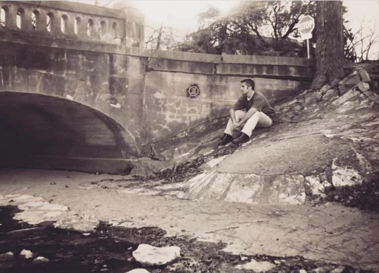 Kevin Wood sitting by a bridge (Courtesy of Kevin Wood)