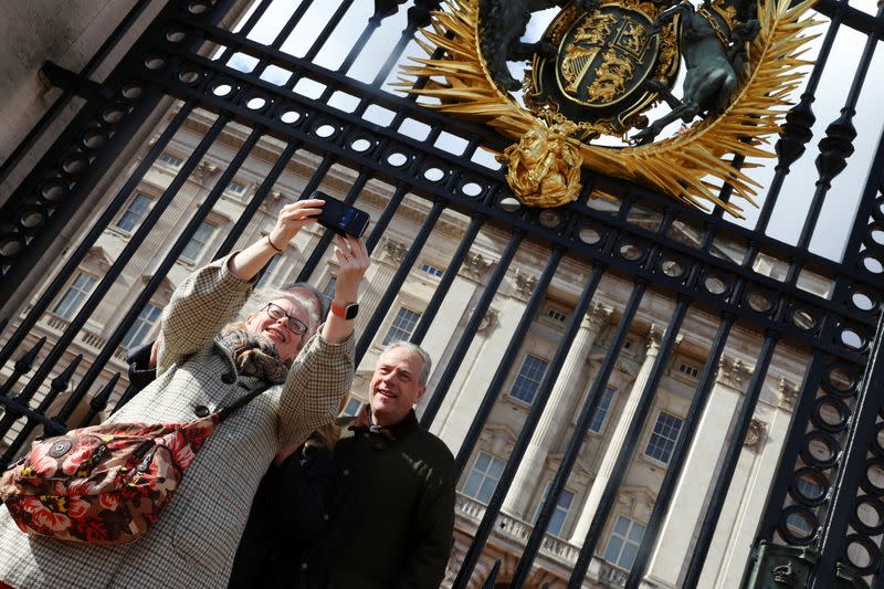Dos personas se fotografían frente al palacio de Buckingham, Londres, Reino Unido.