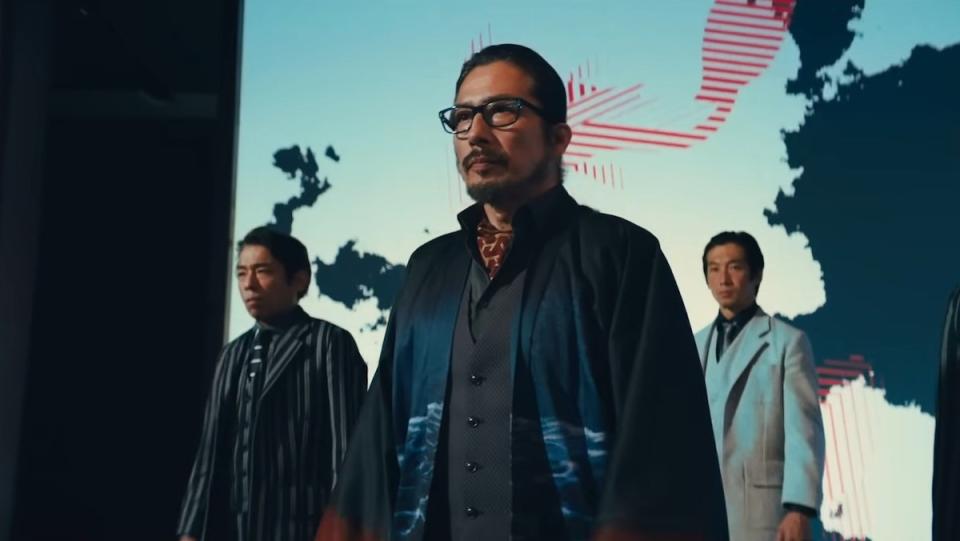 Koji walks through his lobby's hotel with guards behind him in John Wick: Chapter 4