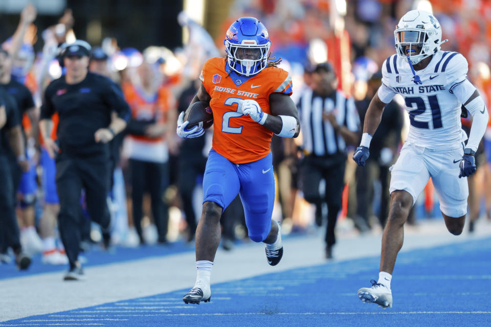 Boise State running back Ashton Jeanty (2) runs away from Utah State safety Malik McConico (21) on a 75-yard touchdown run in the first half of an NCAA college football game, Saturday, Oct. 5, 2024, in Boise, Idaho. . (AP Photo/Steve Conner)