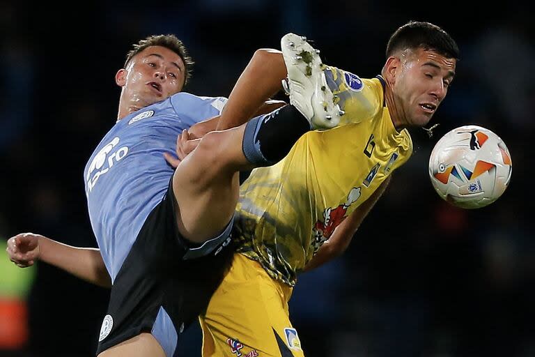 Santiago Longo, volante central de Belgrano, lucha con el mediocampista argentino Nicolas Messiniti, de Delfín, por la Copa Sudamericana