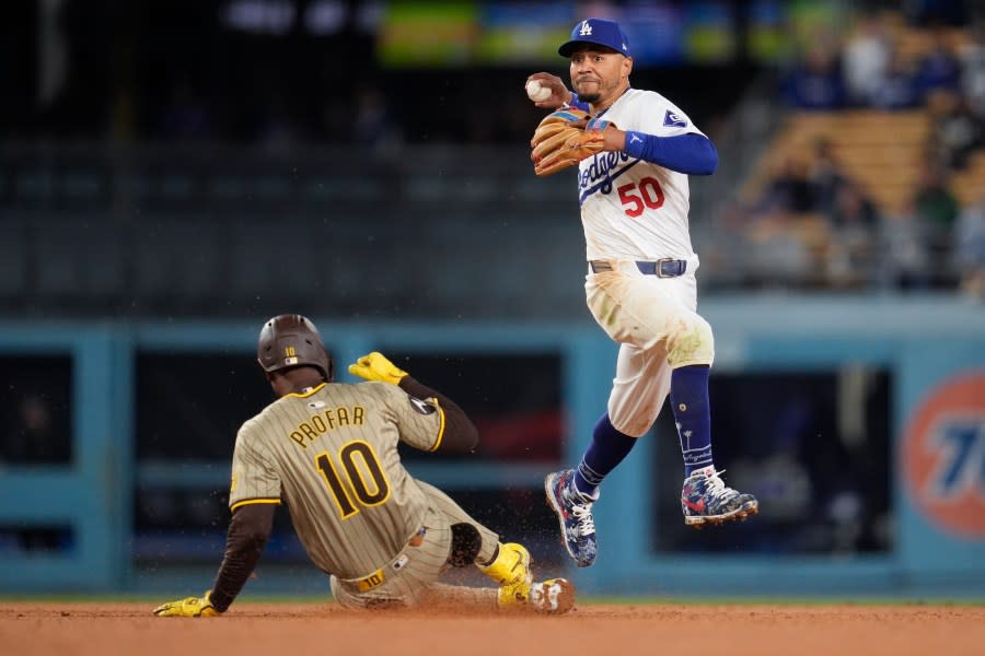 San Diego Padres' Jurickson Profar (10) is out at second base under Los Angeles Dodgers shortstop Mookie Betts during the ninth inning of a baseball game Saturday, April 13, 2024, in Los Angeles. (AP Photo/Marcio Jose Sanchez)