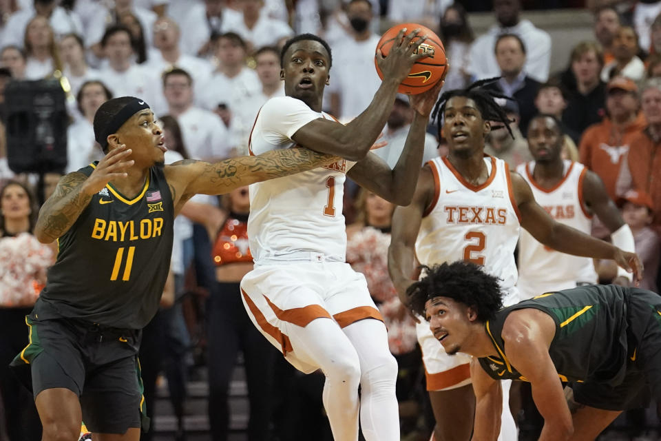 Texas guard Andrew Jones (1) gets possession of the ball next to Baylor guard James Akinjo (11) during the first half of an NCAA college basketball game Monday, Feb. 28, 2022, in Austin, Texas. (AP Photo/Eric Gay)