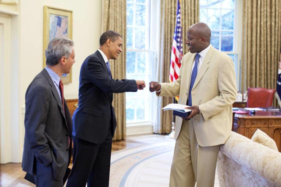 President Barack Obama and Personal Aide Reggie Love fist bump as Chief of Staff Rahm Emanuel looks on, in the Oval Office, June 16, 2009.