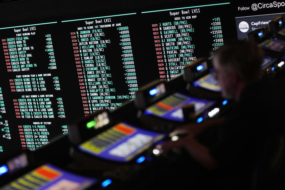 A person gambles as betting odds for NFL football's Super Bowl are displayed on monitors at the Circa resort and casino sports book Friday, Feb. 3, 2023, in Las Vegas. (AP Photo/John Locher)