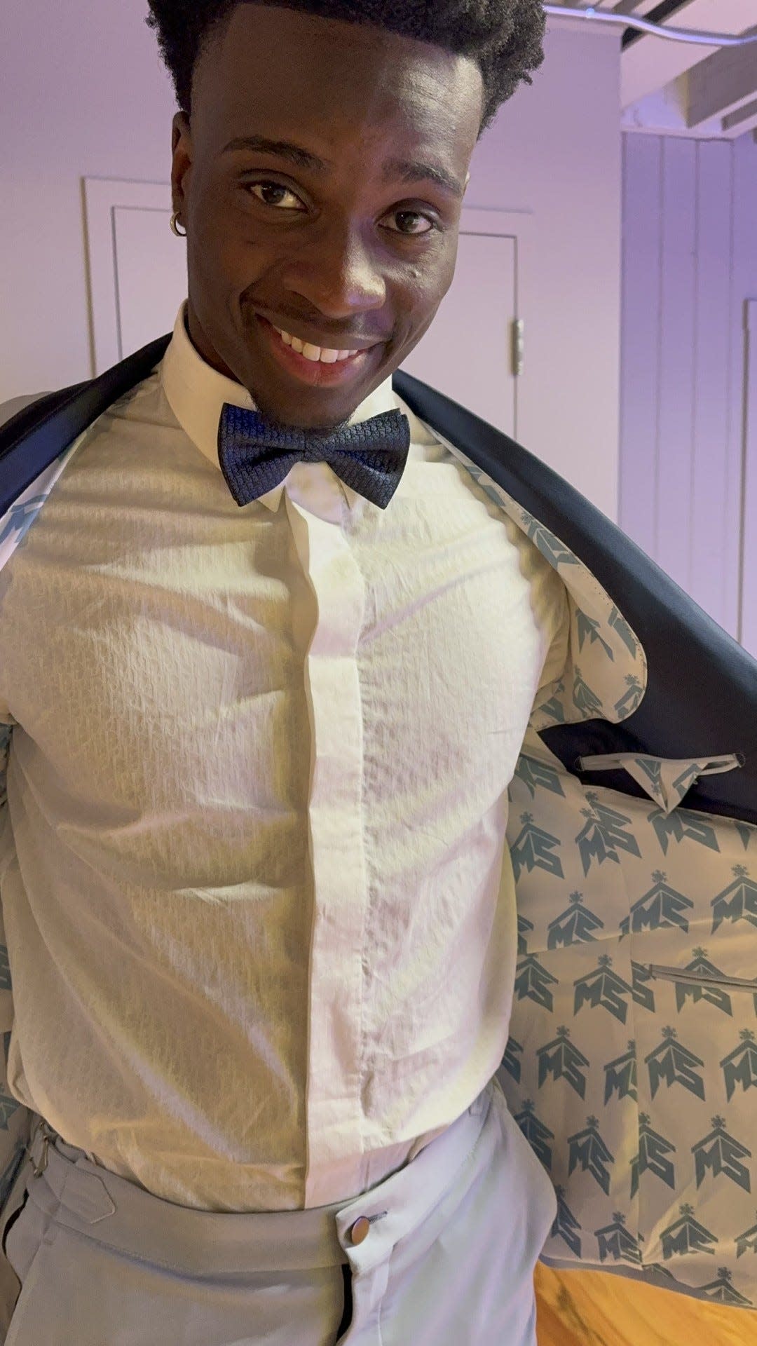Mike Sainristil, coming from the 2024 national champion University of Michigan Wolverines, shows off a custom suit with lining that bears a design around his initials at a draft party Thursday, April 25 at a private event space in n Ann Arbor.