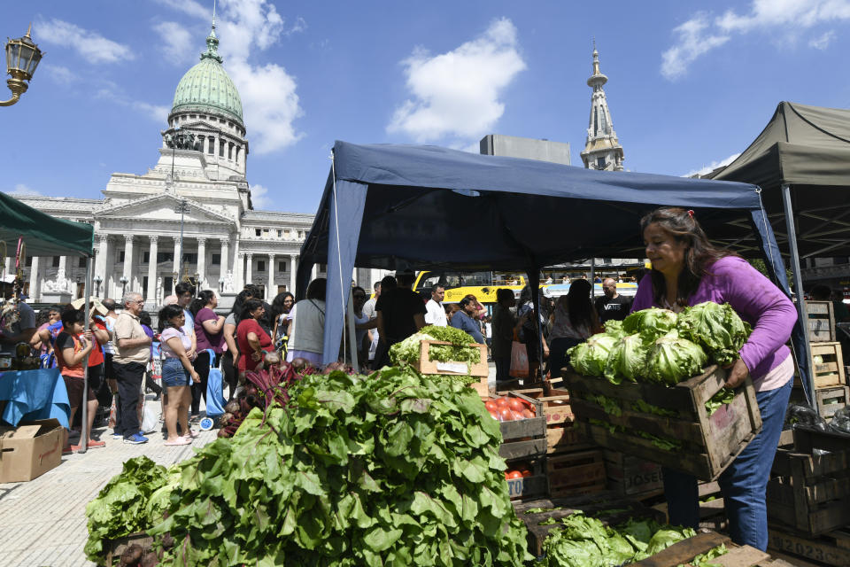 Una integrante de grupos de trabajadores coloca verduras en una feria organizada por organizaciones sociales para vender productos frescos a bajos precios como protesta contra las medidas económicas del presidente Javier Milei, frente al Congreso Nacional, el jueves 21 de diciembre de 2023, en Buenos Aires, Argentina. (AP Foto/Gustavo Garello)