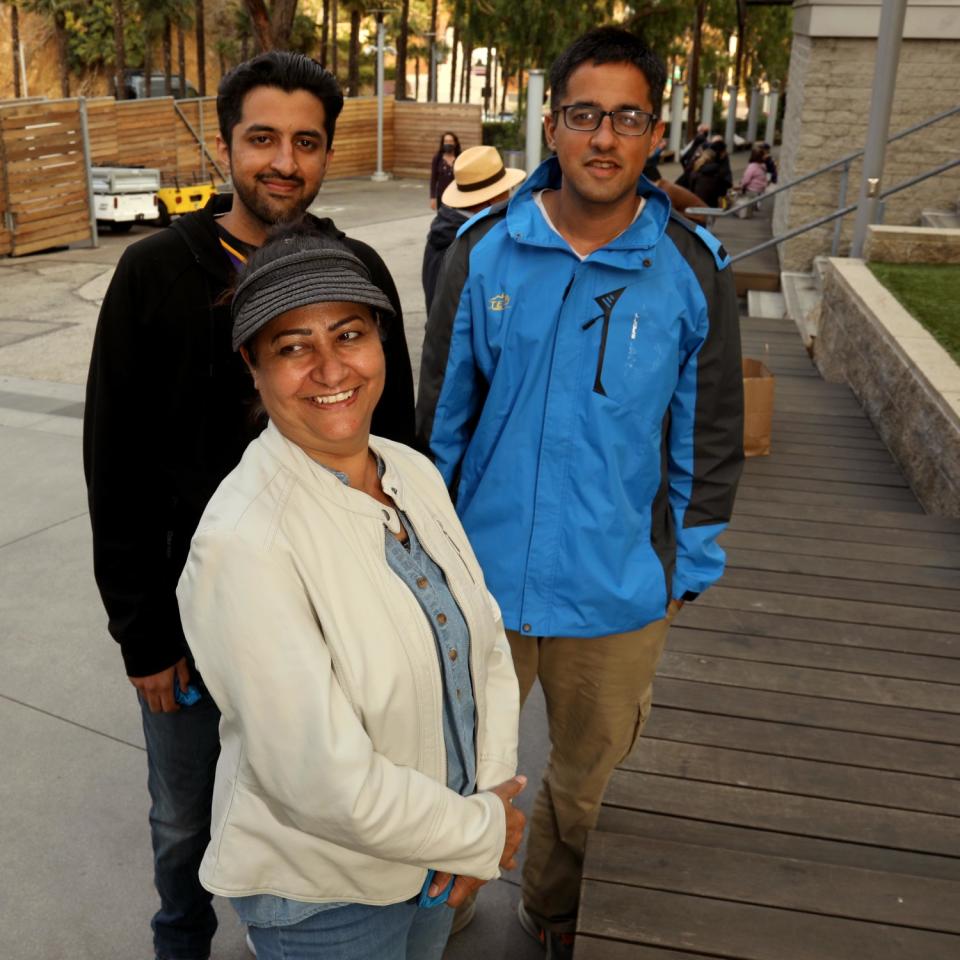 Two men and a woman pose for a photo.