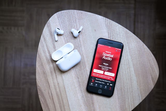 Apple music on an iphone and airpods pro on the table