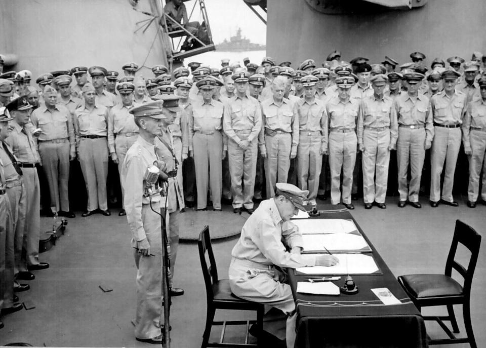 One of the images taken by Saraceno as MacArthur signs the documents.