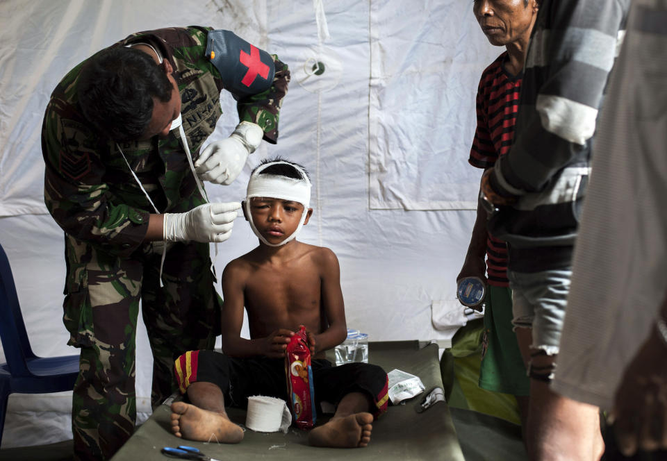 <p>A military paramedic tends to a boy who suffers head injury from Sunday’s earthquake at a makeshift hospital in Kayangan, Lombok Island, Indonesia, Wednesday, Aug. 8, 2018. (Photo: Fauzy Chaniago/AP) </p>