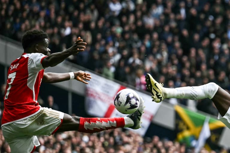 El volante inglés del Arsenal Bukayo Saka (izquierda) controla el balón durante el partido de la Premier League inglesa entre Tottenham Hotspur y Arsenal en el Tottenham Hotspur Stadium de Londres, el 28 de abril de 2024 (Ben Stansall)
