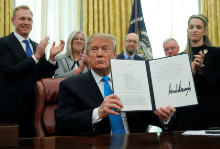 U.S. President Donald Trump displaus the "Space Policy Directive 4" after signing the directive establish a Space Force as the sixth branch of the Armed Forces in the Oval Office at the White House in Washington, U.S., February 19, 2019. REUTERS/Jim Young