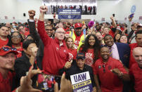 File - United Auto Workers President Shawn Fain, center left, stands for pictures with the Rev. Jesse Jackson, bottom center, after a rally for striking workers at UAW Local 551, on Oct. 7, 2023, in Chicago. Throughout its 5-week-old strikes against Detroit’s automakers, the United Auto Workers union has cast an emphatically combative stance, reflecting the style of Fain, its pugnacious leader. (John J. Kim /Chicago Tribune via AP, File)