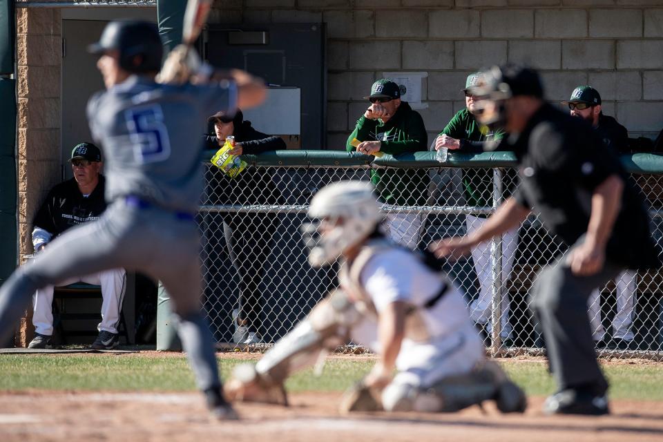 Fossil Ridge's head coach Marc Wagner watches on from the dugout during a city rivalry baseball game against Fort Collins on Tuesday, April 16, 2024 at Fossil Ridge High School in Fort Collins, Colo.