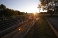 Juscianni Blackeller, 13, center, walks with his sisters, Adaliana and Audrey Gray, ages 5 and 2, near their home in Arlington, Texas, on Monday, Oct. 25, 2021. As their mother, Rosalia Tejeda, has learned more about health risks posed by fracking for natural gas, she has become a vocal opponent of a plan to add more gas wells at a site near their home. "They're everything I live for. Everything I breathe for," Tejeda said. "And just the thought of having them suffer any kind of ailment due to something that is possibly in my control, it would I would kill me." (AP Photo/Martha Irvine)