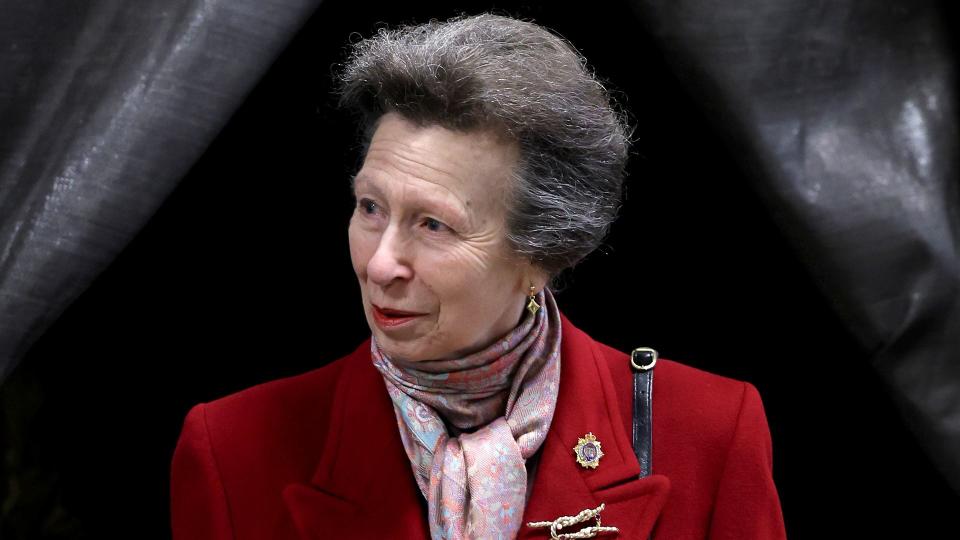 Princess Anne wearing a symbolic brooch with a red coat 