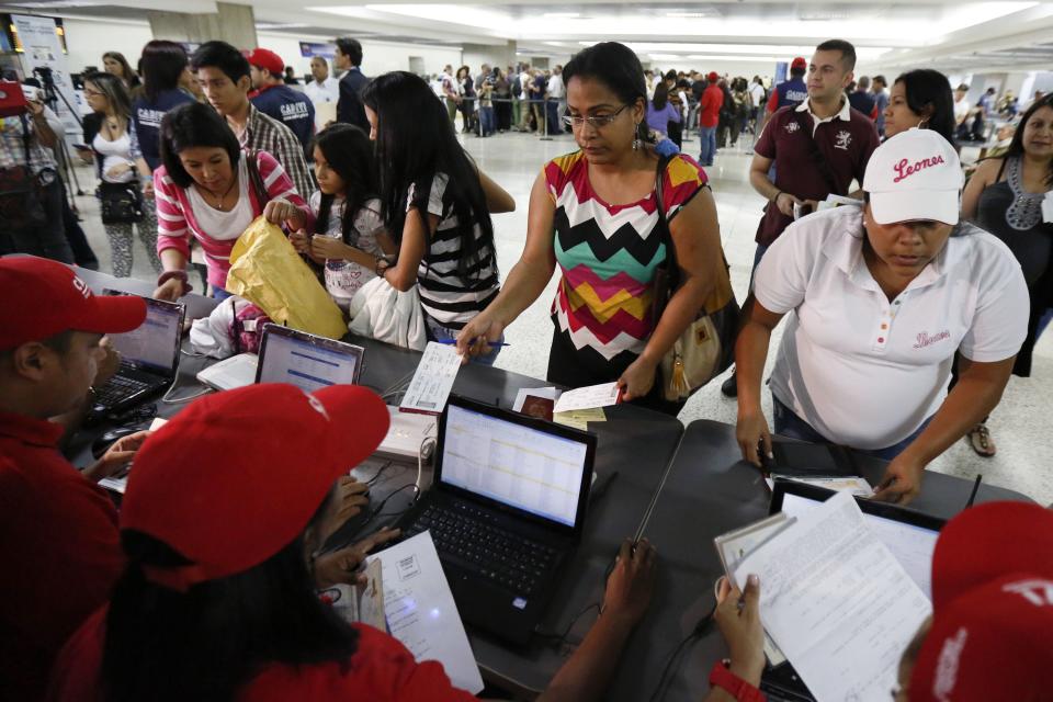 Passengers present their documents at a special check point of the state currency board Cadivi in the Simon Bolivar airport in La Guaira