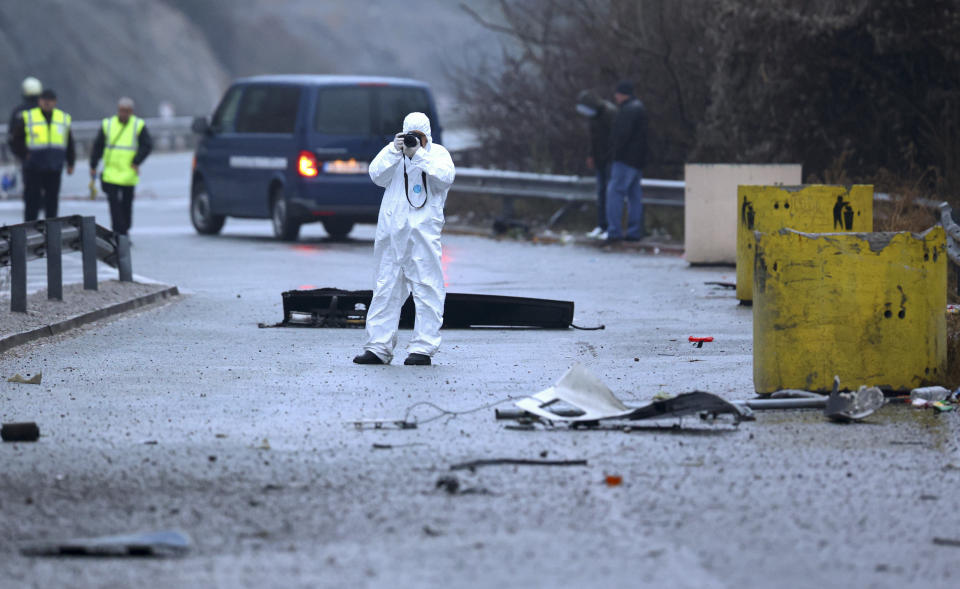 Firefighters and forensic workers inspect the scene of a bus crash which, according to authorities, killed at least 45 people on a highway near the village of Bosnek, western Bulgaria, Tuesday, Nov. 23, 2021. The bus, registered in Northern Macedonia, crashed around 2 a.m. and there were children among the victims, authorities said. (Minko Chernev/BTA Agency Bulgaria via AP)