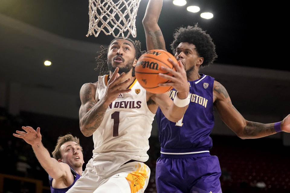 Arizona State guard Frankie Collins (1) drives to the basket against Washington forward Moses Wood, left, and forward Keion Brooks Jr. (1) during the second half of an NCAA college basketball game Thursday, Feb. 22, 2024, in Tempe, Ariz. (AP Photo/Darryl Webb)