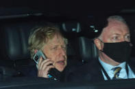 Prime Minister Boris Johnson (left) rides in the back seat of a government car while speaking on a mobile phone as he returns to Downing Street, London, following PMQs at the Houses of Parliament. The Prime Minister is set to face further questions over a police investigation into partygate as No 10 braces for the submission of Sue Gray's report into possible lockdown breaches. Picture date: Wednesday January 26, 2022.