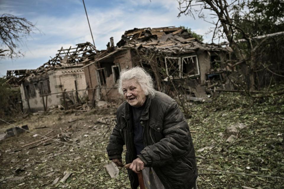 An old woman walks amid the ruins of Druzhkivka, eastern Ukraine on 5 June, 2022 (AFP via Getty Images)