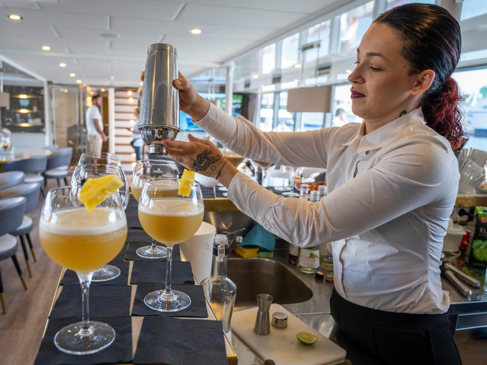 A waitress is pouring a drink.