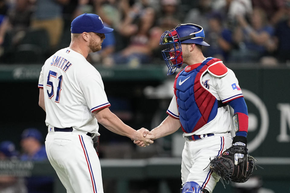Texas Rangers' Will Smith (51) and catcher Mitch Garver, right, celebrate after their team's 2-0 win in a baseball game against the Chicago White Sox, Tuesday, Aug. 1, 2023, in Arlington, Texas. (AP Photo/Tony Gutierrez)