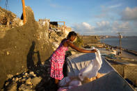 <p>Andrenne Joseph dries her clothes near her destroyed house caused by Hurricane Matthew, in Jeremie, Haiti. Saturday Oct. 8, 2016. (AP Photo/Dieu Nalio Chery)</p>