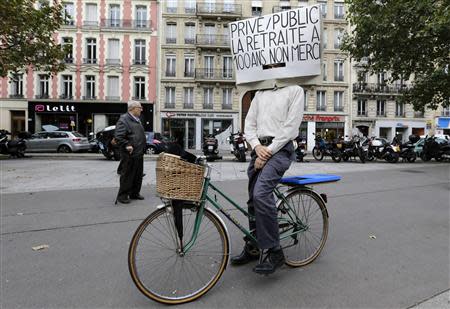 A man on his bicycle attends a demonstration over pension reforms in Paris, September 10, 2013. REUTERS/Jacky Naegelen