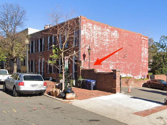 A house with a red arrow pointing at a wall.