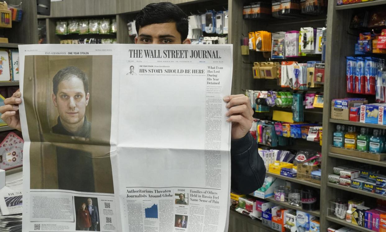 <span>A New York City vendor holds a copy of the Wall Street Journal marking the first anniversary of Evan Gershkovich’s detention in Russia.</span><span>Photograph: Timothy A Clary/AFP/Getty Images</span>