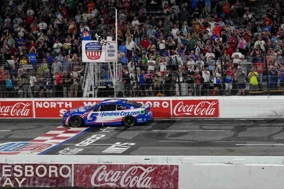 Kyle Larson takes the checkered flag to win the NASCAR All Star Race at North Wilkesboro Speedway on May 21, 2023.