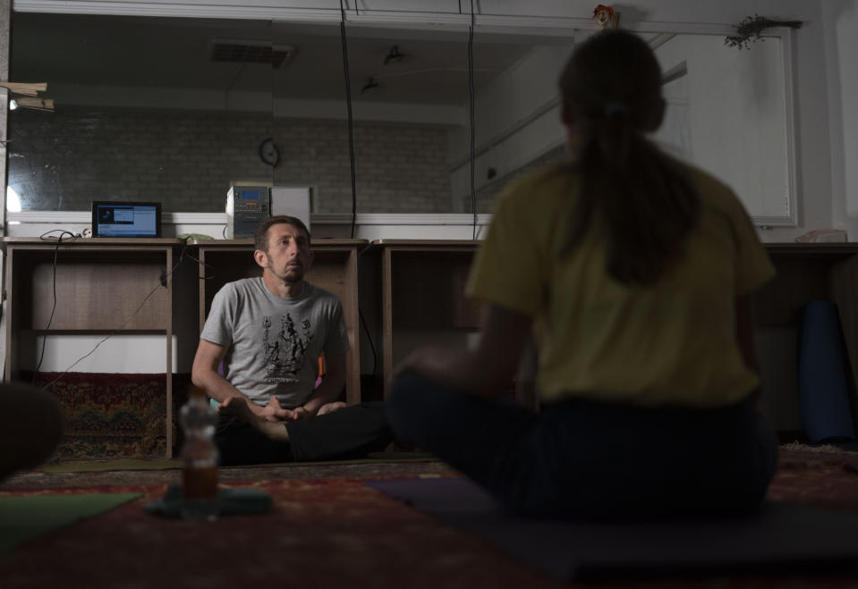 El instructor Serhii Zaloznyi realiza una sesión de yoga en un sótano en Kramatorsk, en la región de Donetsk, Ucrania, el jueves 14 de septiembre de 2023. (AP Foto/Hanna Arhirova)