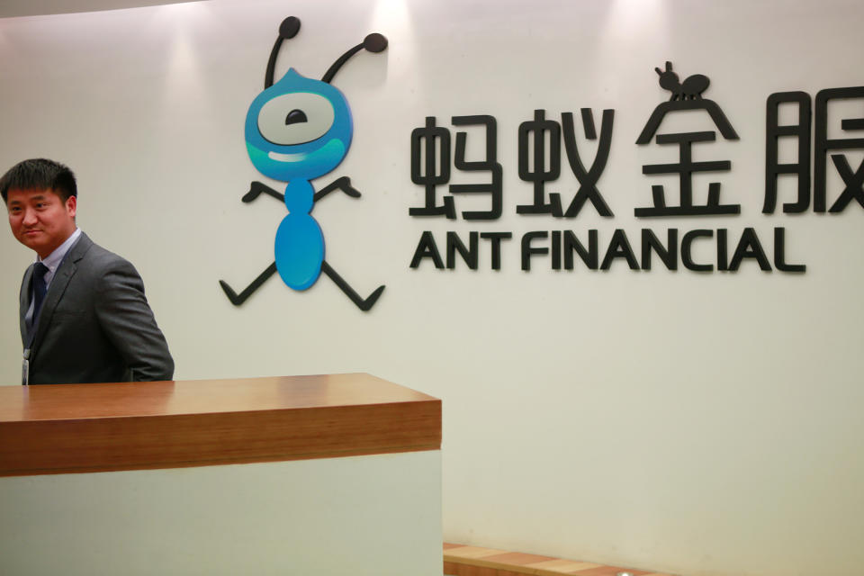 FILE PHOTO: Employee stands next to the logo of Ant Financial Services Group at its headquarters in Hangzhou