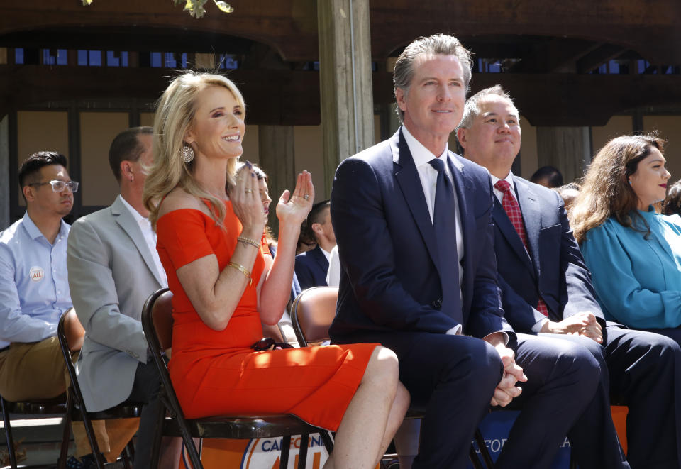 FILE-- In this July 1, 2019 file photo First Partner Jennifer Siebel Newsom, left, attends a big signing ceremony with her husband, Gov. Gavin Newsom, right, at Sacramento City College in Sacramento, Calif. Siebel Newsom has shunned the traditional title of "first lady" and is focusing on women's issues including equal pay and expanding family leave. (AP Photo/Rich Pedroncelli, File)