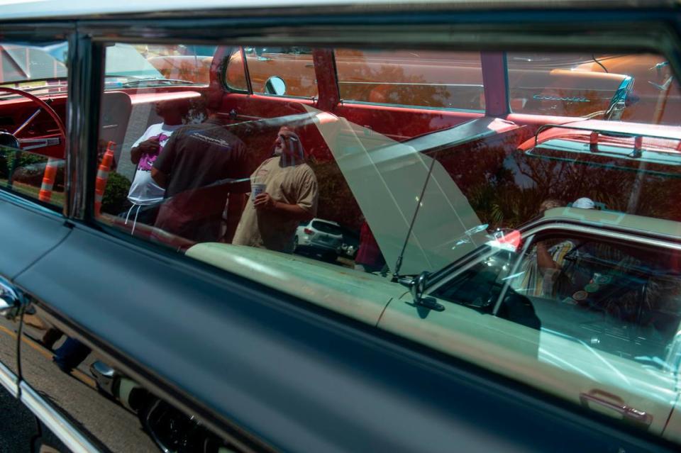 Spectators are reflected in the window of a station wagon parked in downtown Biloxi during the Biloxi Block Party, one of many Cruisin’ the Coast events, on Wednesday, Oct. 4, 2023. Hannah Ruhoff/Sun Herald