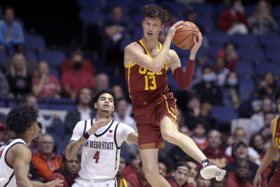 Southern California guard Drew Peterson, right, pulls down a loose ball in front of San Diego State guard Trey Pulliam (4) during the first half of an NCAA college basketball game at the Wooden Legacy tournament in Anaheim, Calif., Friday, Nov. 26, 2021. (AP Photo/Alex Gallardo)