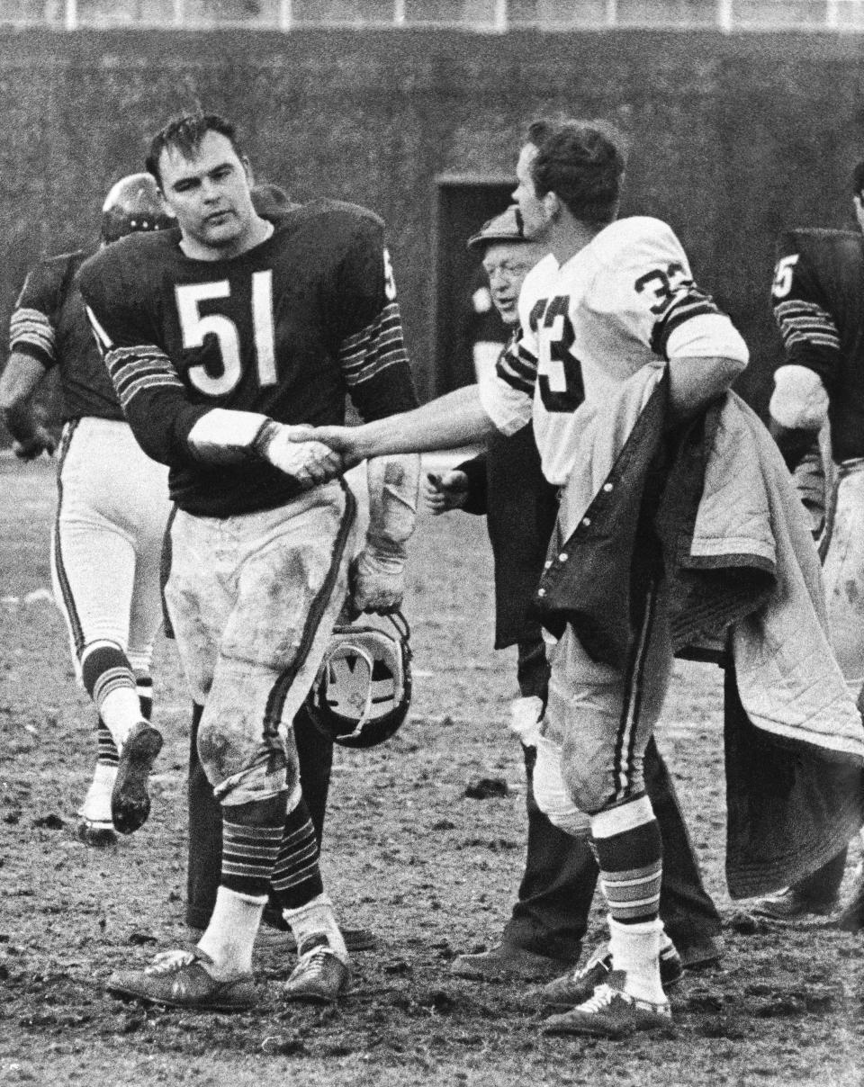 FILE - Chicago Bears' Dick Butkus (51) shakes hands with Green Bay Packers' Jim Grabowski after an NFL football game in Chicago, Nov. 26, 1967. Butkus and Grabowski were teammates at the University of Illinois several years ago. Butkus, a fearsome middle linebacker for the Bears, has died, the team announced Thursday, Oct. 5, 2023. He was 80. According to a statement released by the team, Butkus' family confirmed that he died in his sleep overnight at his home in Malibu, Calif. (AP Photo/Charles Harrity, File)
